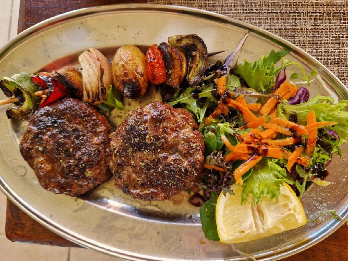 Greek dish beef burger with salad and grilled vegetables